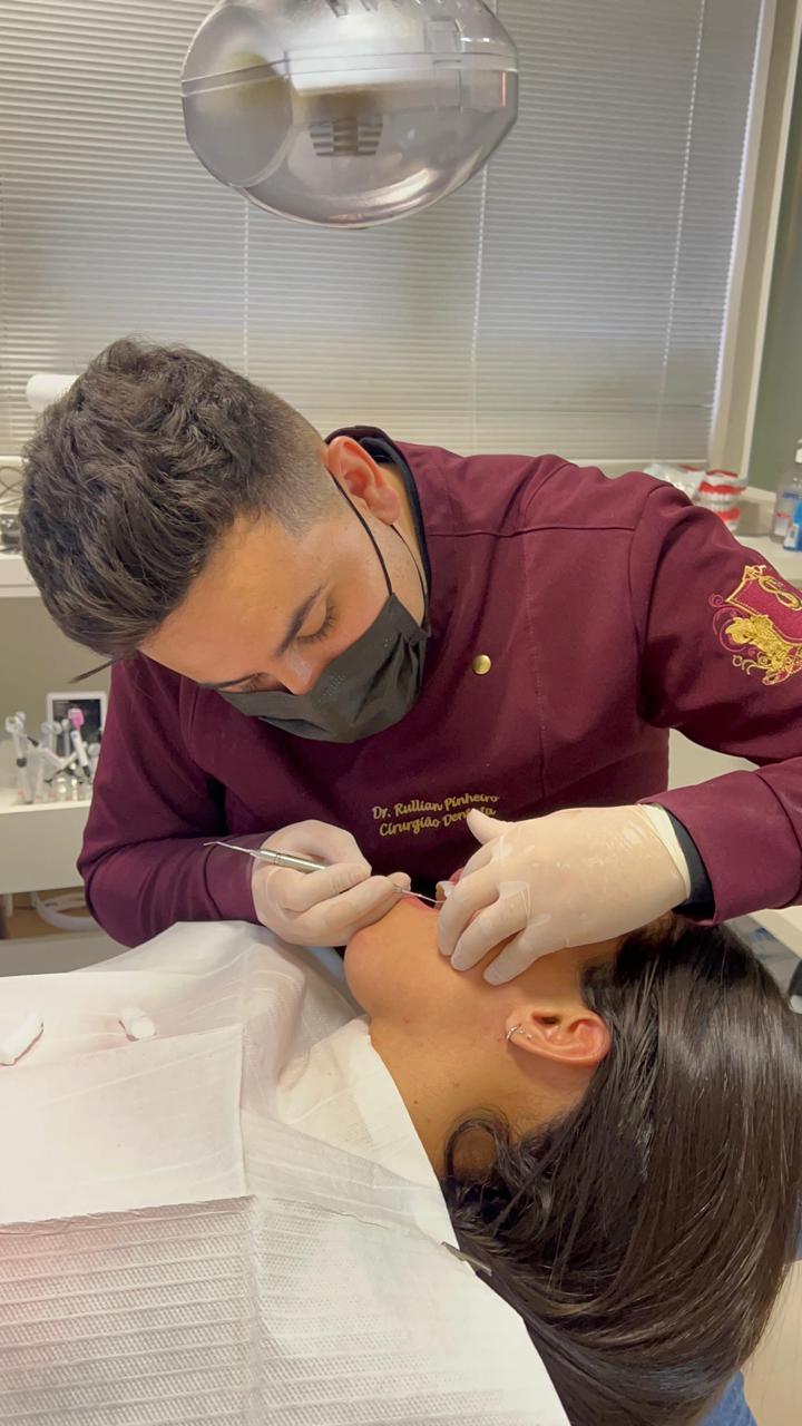 Dr. Rullian Pinheiro realizando atendimento odontológico no consultório em Curitiba